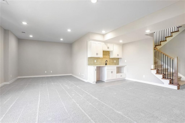 7090 NW Forest Lakes Dr, Parkville, MO 64152 - unfurnished living room with light colored carpet, recessed lighting, and stairway