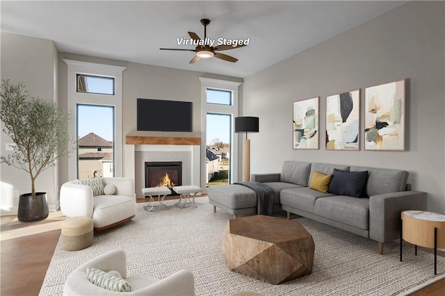 7090 NW Forest Lakes Dr, Parkville, MO 64152 - living area with wood finished floors, ceiling fan, and a glass covered fireplace