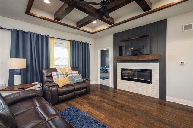 living room with coffered ceiling, beamed ceiling, a fireplace, dark wood-type flooring, and ceiling fan