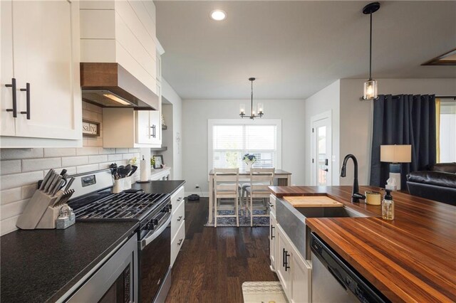 kitchen featuring white cabinetry, stainless steel appliances, and hanging light fixtures