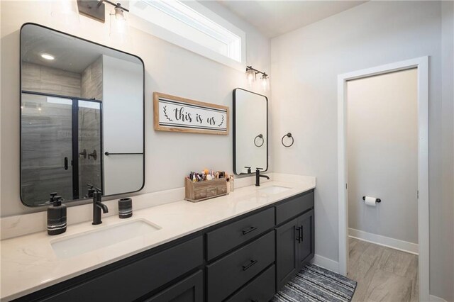 bathroom with hardwood / wood-style floors, walk in shower, and vanity