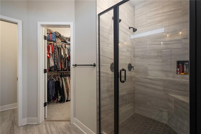 bathroom with wood-type flooring and an enclosed shower