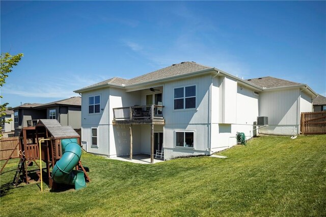 back of property featuring central AC, a patio, a balcony, a yard, and a playground