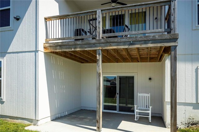 entrance to property featuring a balcony, a patio area, and ceiling fan