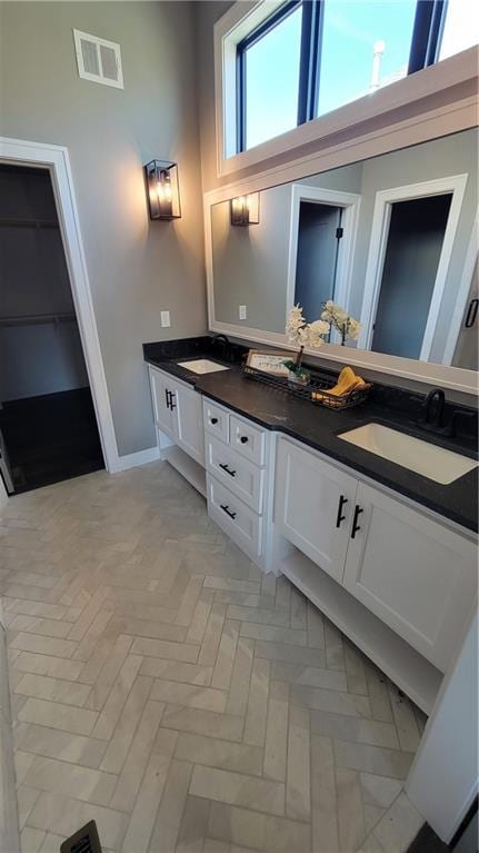 bathroom featuring vanity, a healthy amount of sunlight, and a towering ceiling