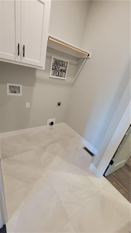 washroom featuring light hardwood / wood-style flooring, washer hookup, hookup for an electric dryer, and cabinets