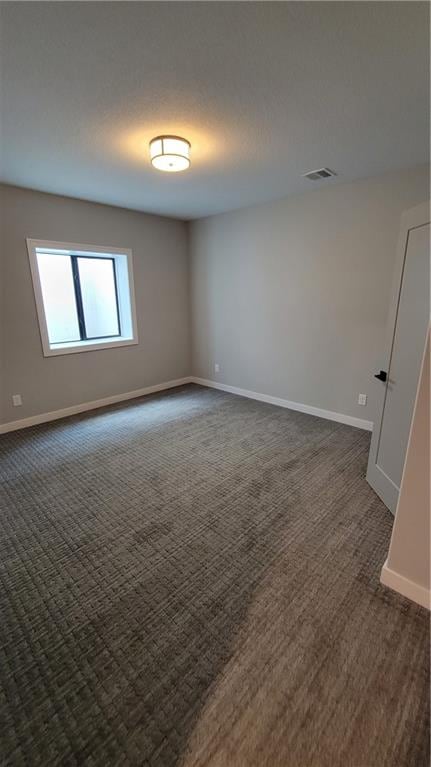 empty room with dark colored carpet