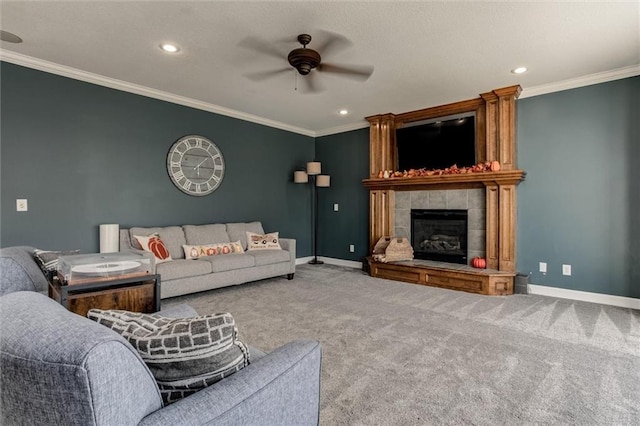 living room featuring a tile fireplace, ceiling fan, light colored carpet, and crown molding