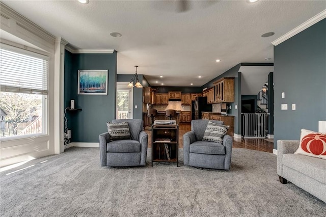 carpeted living room with a chandelier, a textured ceiling, a healthy amount of sunlight, and crown molding