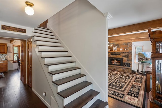 stairway featuring hardwood / wood-style floors and a fireplace