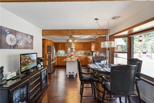 dining space featuring beam ceiling, ceiling fan, and dark hardwood / wood-style floors