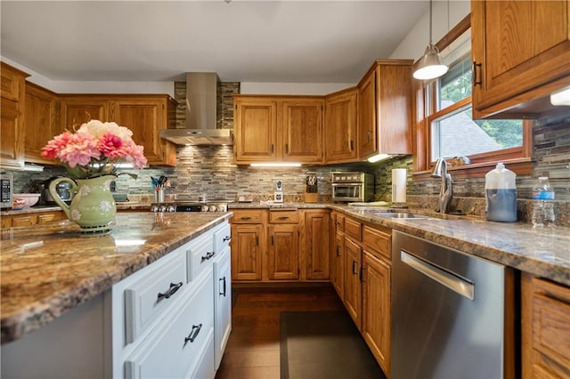 kitchen featuring white cabinets, light stone counters, wall chimney range hood, pendant lighting, and stainless steel dishwasher