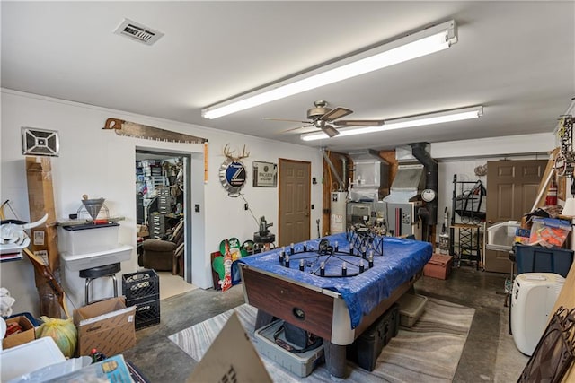 game room featuring gas water heater, concrete flooring, and ceiling fan