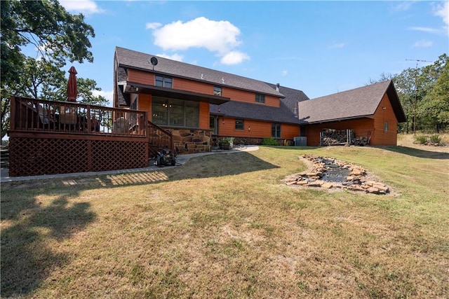 back of house featuring a wooden deck and a lawn