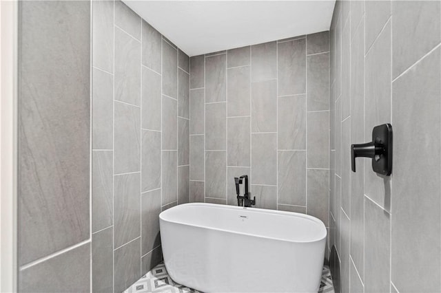 bathroom with a bathing tub and tile walls