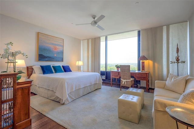 bedroom with expansive windows, hardwood / wood-style floors, and ceiling fan