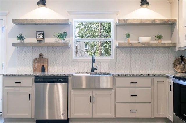 kitchen with light stone countertops, decorative backsplash, white cabinetry, and appliances with stainless steel finishes