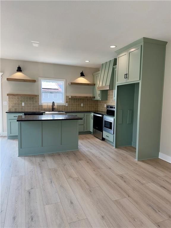 kitchen featuring wall chimney exhaust hood, light hardwood / wood-style floors, and green cabinets