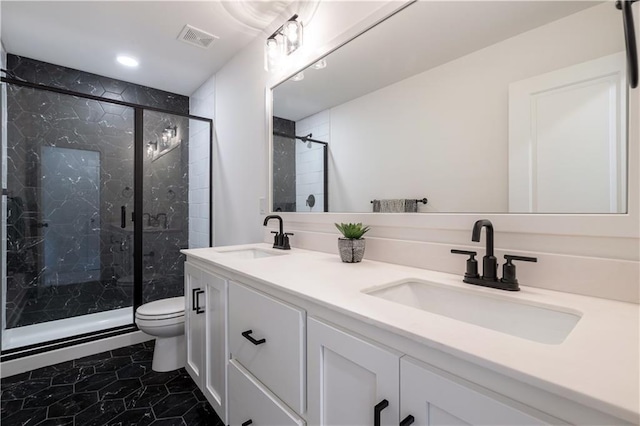 bathroom with tile patterned floors, a shower with door, vanity, and toilet