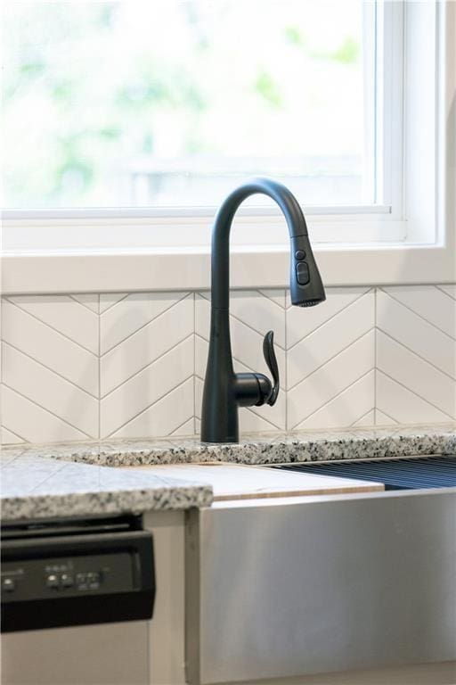 details featuring dishwasher and light stone countertops