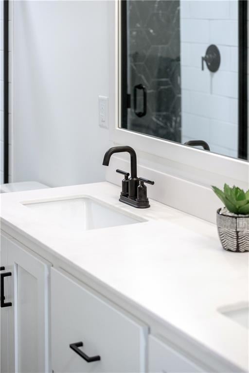 bathroom with a shower with door and vanity