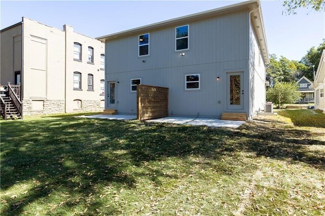 back of house featuring central AC unit, a yard, and a patio