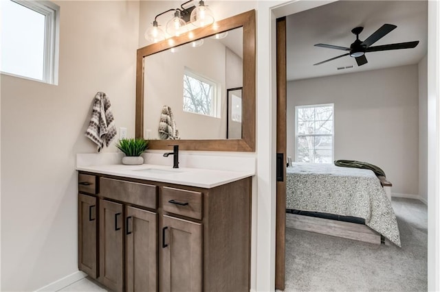 bathroom with ceiling fan, vanity, and a healthy amount of sunlight