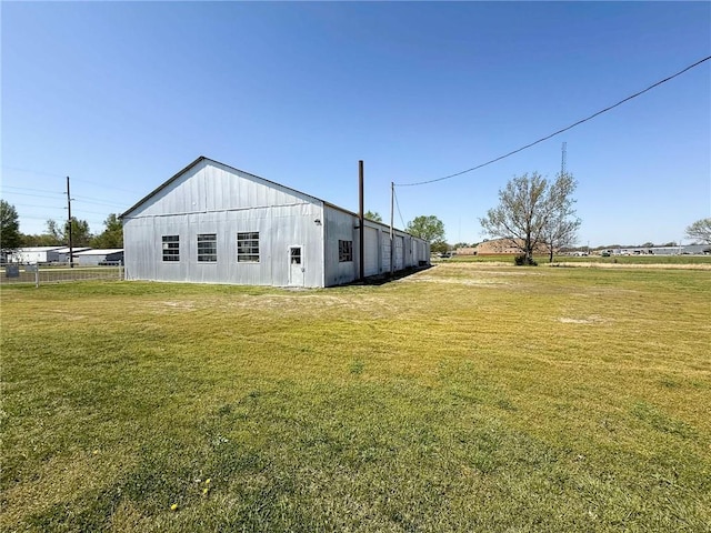 back of house with a yard, board and batten siding, and an outbuilding