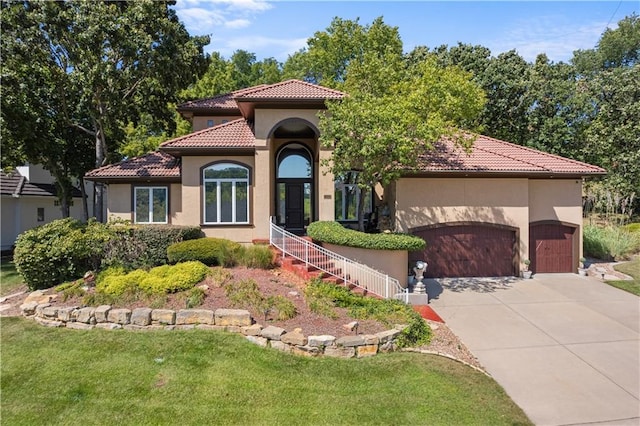 mediterranean / spanish house with a front lawn and a garage