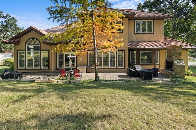 back of property with a lawn and a patio