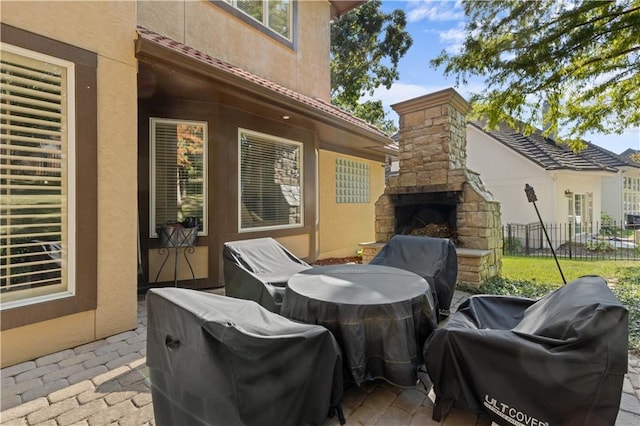 view of patio / terrace featuring area for grilling and an outdoor stone fireplace