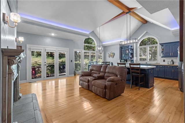 living room with light hardwood / wood-style flooring, an inviting chandelier, and a healthy amount of sunlight