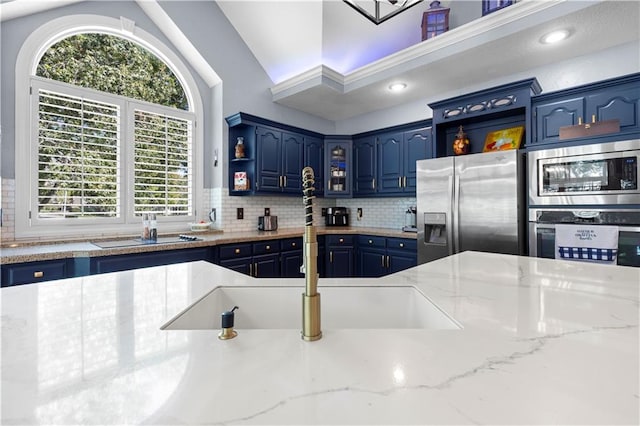 kitchen featuring blue cabinets, plenty of natural light, stainless steel appliances, and backsplash