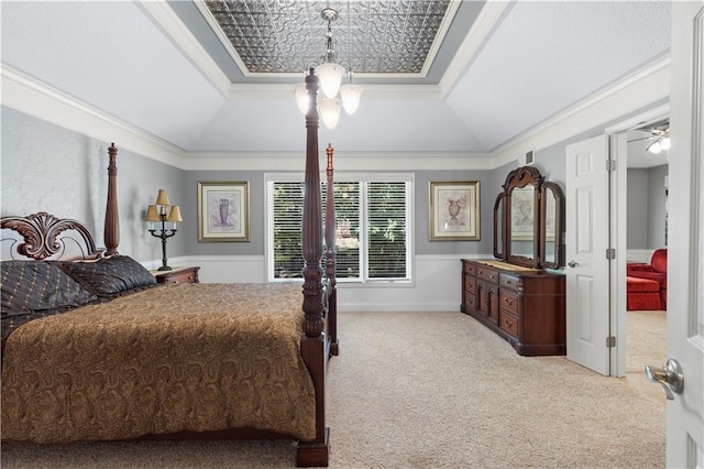 carpeted bedroom featuring ornamental molding, a chandelier, and a tray ceiling