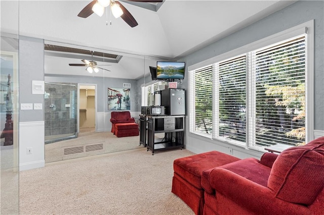 living room featuring vaulted ceiling, ceiling fan, and carpet flooring