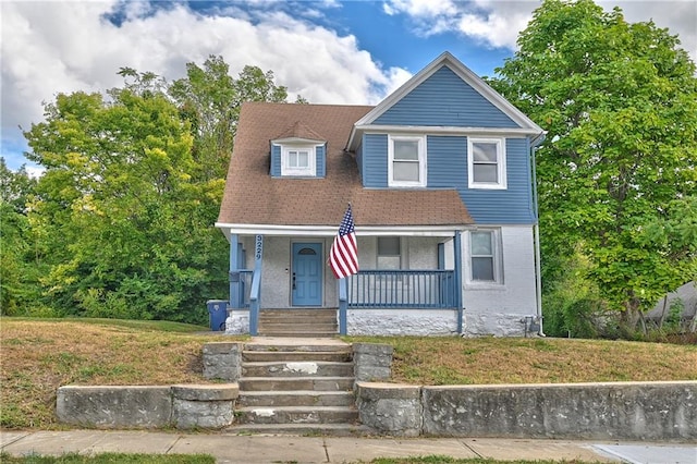 view of front of house with a front yard and covered porch