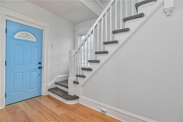 3229 Wayne Ave, Kansas City, MO 64109 - entrance foyer featuring stairway, baseboards, visible vents, light wood-style floors, and a textured wall