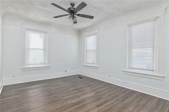 3229 Wayne Ave, Kansas City, MO 64109 - empty room featuring dark wood finished floors, baseboards, and a textured ceiling