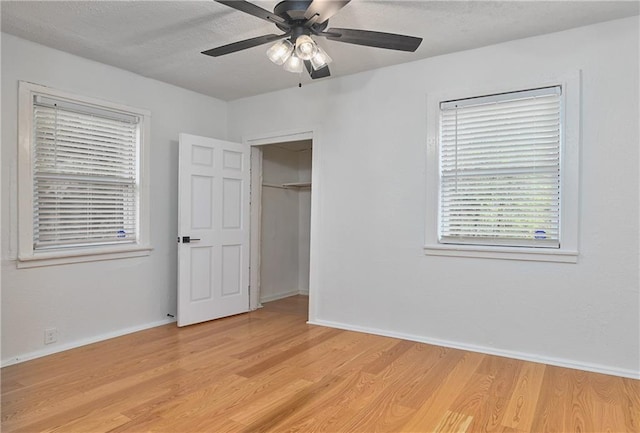 3229 Wayne Ave, Kansas City, MO 64109 - unfurnished bedroom with baseboards, a closet, light wood-style flooring, and a textured ceiling