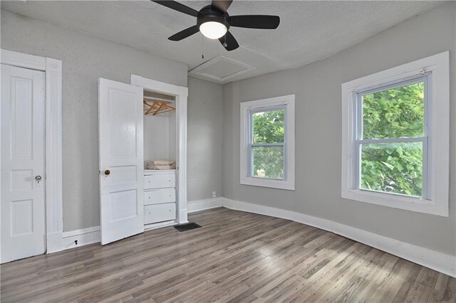 3229 Wayne Ave, Kansas City, MO 64109 - unfurnished bedroom featuring wood finished floors, a textured ceiling, baseboards, visible vents, and ceiling fan