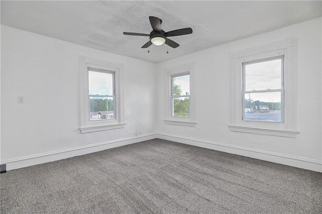 carpeted empty room with ceiling fan and a healthy amount of sunlight