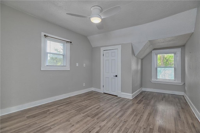 3229 Wayne Ave, Kansas City, MO 64109 - additional living space featuring lofted ceiling, a textured ceiling, and wood finished floors
