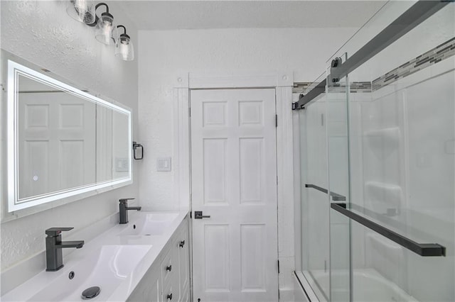 bathroom with a shower with door and vanity