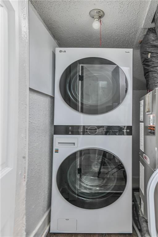 3229 Wayne Ave, Kansas City, MO 64109 - laundry room with a textured ceiling, laundry area, and stacked washer / drying machine