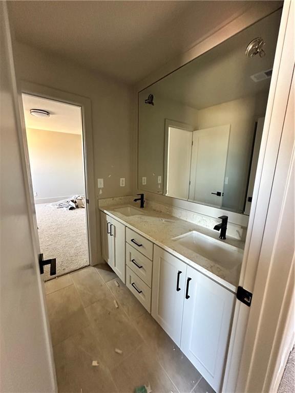 full bathroom featuring double vanity, visible vents, tile patterned flooring, and a sink