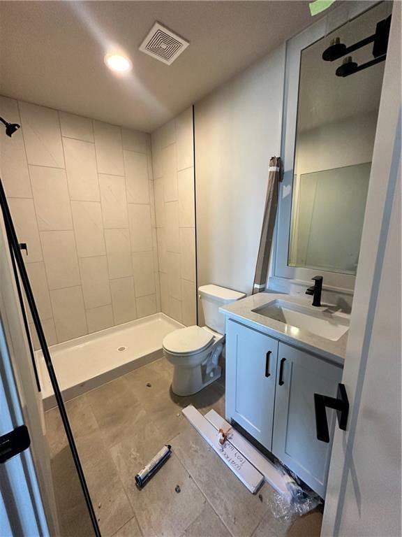 full bathroom featuring visible vents, a shower stall, toilet, and vanity