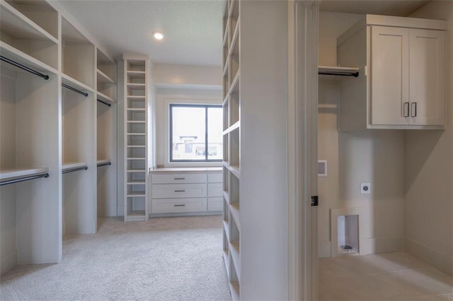 walk in closet with light colored carpet