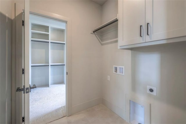 laundry area with light tile patterned floors, baseboards, hookup for an electric dryer, cabinet space, and hookup for a washing machine