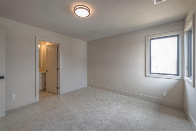 spare room featuring baseboards and light colored carpet