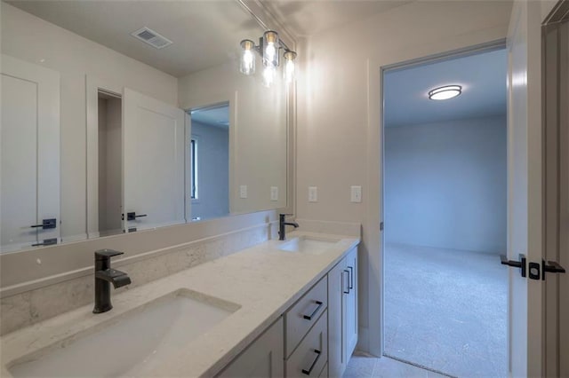 bathroom with double vanity, visible vents, and a sink